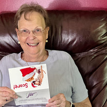 Load image into Gallery viewer, Woman smiling with joy as she opens a Christmas card featuring a cute chihuahua and a festive message.