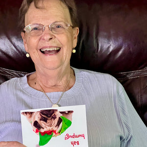 Woman laughing while receiving the cute 'Bah humpug!' birthday card, perfect for friends and family.