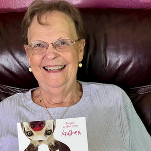 A woman smiling while receiving the humorous "Naughty and I Regret Nothing" card.