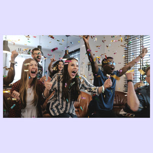 Group of people celebrating with confetti in an office setting.