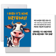 Load image into Gallery viewer, Front of the blue greeting card with a smiling cow and &quot;I Herd It&#39;s Your Birthday!&quot; in gold letters. Inside, in black it says, &quot;My wish for you is that your milk is always fresh and your burgers are always made from plants! Cheers to another spin around the sun!&quot;
