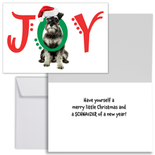 Load image into Gallery viewer, Christmas card with the word JOY across the front with a schnauzer dog  putting his head through the O in JOY. The J and Y are in red font and the O is in green. Each letter has some decorative dots.  The inside of the card reads, &quot;Have yourself a merry little Christmas and a SCHNAZUER of a new year!&quot; There is one 1 white envelope.
