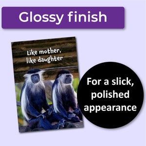 Greeting card with two monkeys and text 'Like mother, like daughter' on a wooden background. A purple banner at the top that says, "Glossy finish" and a black circle with text that says, "For a slick, polished appearance."