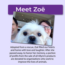 Load image into Gallery viewer, White dog being held by two people with a purple banner above that reads, &quot;Meet Zoë&quot; and text below that reads, &quot;Adopted from a rescue, Zoë filled our hearts and home with love and laughter. After she passed away, to honor her memory, a portion of profits from the sale of all Allynn&#39;s products are donated to organizations who work to improve the lives of animals.&quot;
