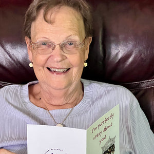 Woman joyfully receiving a cute and funny cat greeting card.